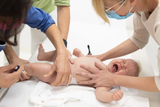 Baby beeing vaccinated by pediatrician in presence of his mother. Preventive vaccination against Diphtheria, whooping cough, tetanus, hepatitis, haemophilus influenzae, pneumococcus, poliomyelitis.