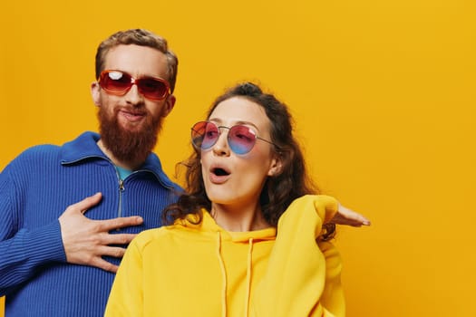 Man and woman couple smiling cheerfully and crooked with glasses, on yellow background, symbols signs and hand gestures, family shoot, newlyweds. High quality photo