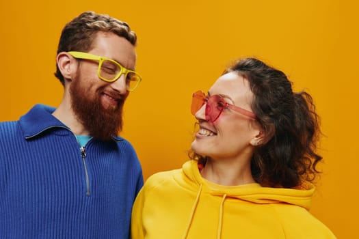 Man and woman couple smiling cheerfully and crooked with glasses, on yellow background, symbols signs and hand gestures, family shoot, newlyweds. High quality photo