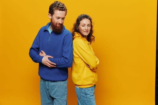 Man and woman couple smiling cheerfully and crooked with glasses, on yellow background, symbols signs and hand gestures, family shoot, newlyweds. High quality photo