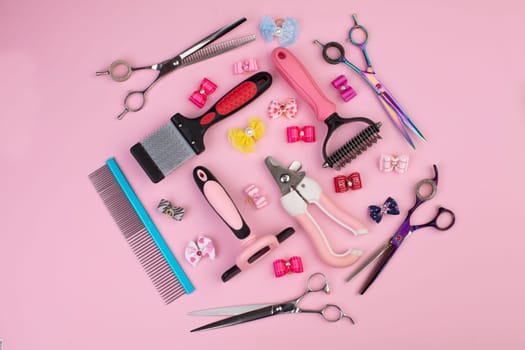 Tool for the groomer on a pink background. Dog grooming accessories. Combs and brushes for animals. View from above