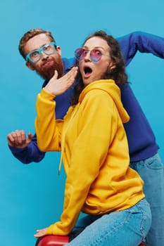 Woman and man smile sitting on suitcase with red suitcase smile, on blue background, packing for trip, family vacation trip. High quality photo