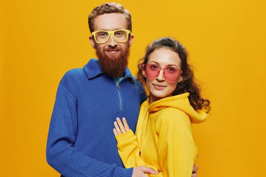 Man and woman couple smiling cheerfully and crooked with glasses, on yellow background, symbols signs and hand gestures, family shoot, newlyweds. High quality photo