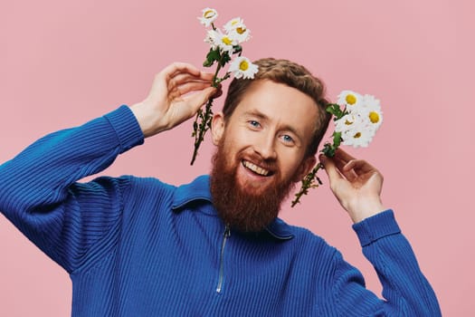 Portrait of a funny man smiling with a bouquet of flowers daisies on pink isolated background, copy place. Holiday concept and congratulations, Valentine's Day, Women's Day. High quality photo