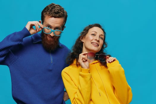 A woman and a man fun couple cranking and showing signs with their hands smiling cheerfully, on a blue background, The concept of a real relationship in a family. High quality photo