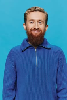 Portrait of man redheaded man with beard in sweater smile and happiness, hand signs and symbols, on blue background. Lifestyle positive, copy place. High quality photo