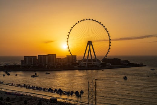 Sunset behind Ain Dubai or Dubai Eye Observation Wheel on BlueWaters Island off the coast by JBR beach