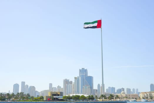 SHARJAH, UAE - February 14, 2023: Flag of the United Arab Emirates in Sharjah on the coastline.