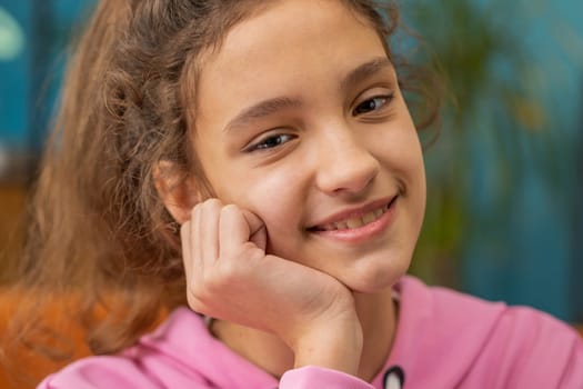 Close-up portrait of happy calm beautiful preteen school girl smiling friendly, glad expression looking at camera dreaming resting, relaxation feel satisfied good news. Young child kid at home room