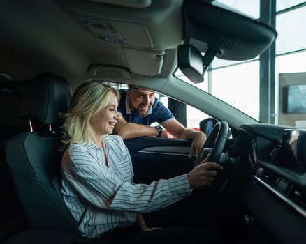 Caucasian family chooses a car. A woman is driving and a man is looking out the window