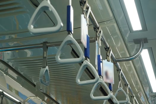 Close up and selective focus of grey triangle handle bar in the train of MRT Jakarta, Indonesia. Blurred background with copy space.