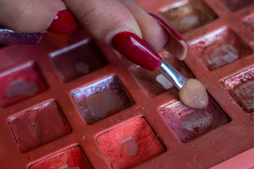 close-up of a girl's fingers holding a brush in a makeup case. High quality photo