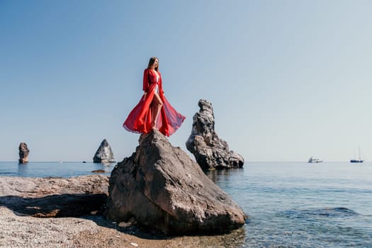 Woman travel sea. Happy tourist taking picture outdoors for memories. Woman traveler looks at the edge of the cliff on the sea bay of mountains, sharing travel adventure journey.