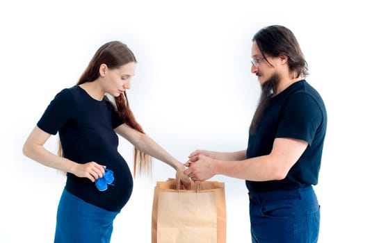 Portrait happy young pregnant woman and her husband with shopping bags and touching her big belly isolated on white background. Pregnancy shopping concept happy young family with shopping bags