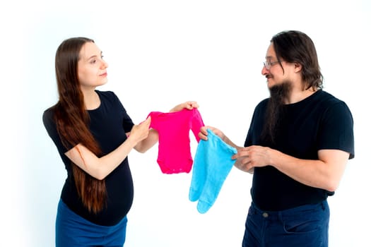 young pregnant woman and her husband with shopping bags andchoose blue for a boy or pink for a girl on white background. Pregnancy shopping concept happy young family with shopping bags