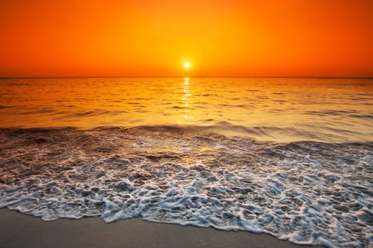 Beach sunrise or sunset over the ocean and sky with sun