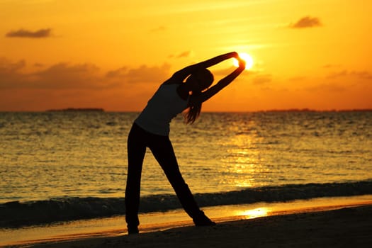 sunset yoga woman on sea coast