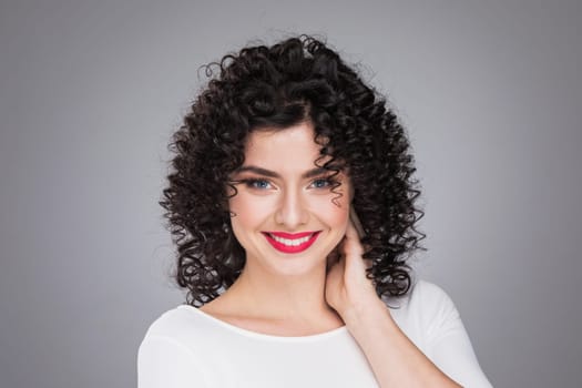 Photo portrait of beautiful girl with curly hairstyle on gray background