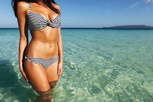 Beautiful young woman in bikini posing in sea 