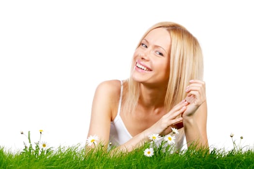 Beautiful young blonde woman lying on grass with chamomile flowers, isolated on white background