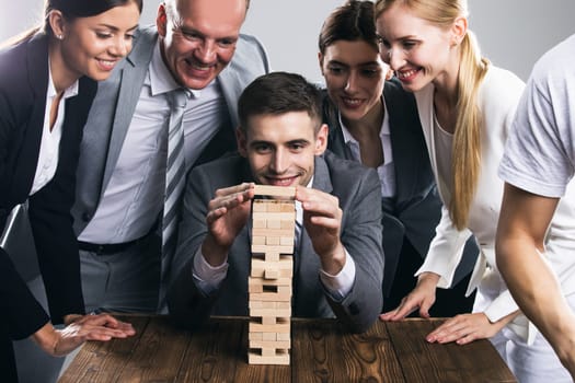 Business people team building wood puzzle tower cooperation concept