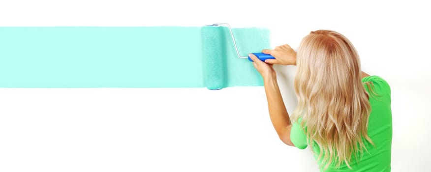 woman paints the wall brush