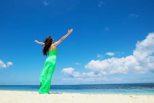 Happy woman enjoy vacation on beach walking with raised hands