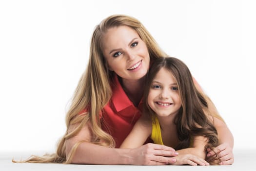 Mother and daughter lying on the floor isolated on white background