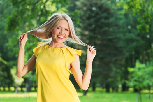 happy woman posing against a background of trees