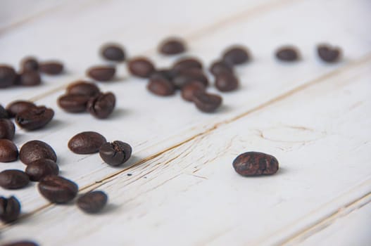Scattered coffee beans on wooden cover background with customizable space for text or coffee ideas.