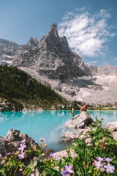couple on vacation in the Italian Dolomites, Lago di Sorapis, Lake Sorapis, Dolomites, Italy. men and woman by the lake