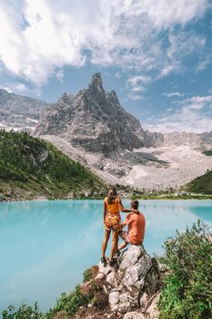couple on vacation in the Italian Dolomites, Lago di Sorapis, Lake Sorapis, Dolomites, Italy. men and woman by the lake
