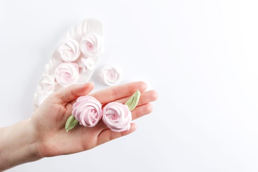 Meringue. Light dessert of whipped egg whites on a female hand .copy space