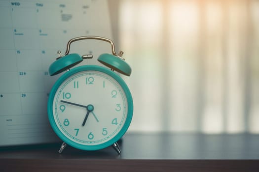 An alarm clock with calendar on the desk for the concept of time and date management.