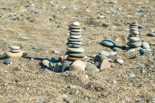 large pebbles stacked on the sand of the beach. photo