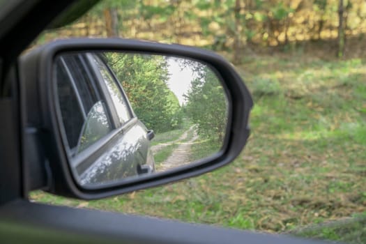 reflection of the forest road in the car mirror. photo