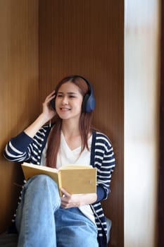 Portrait of a loving Asian teenage girl wearing headphones using a notebook while listening to an online lesson.