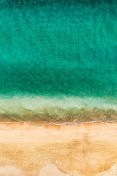 Beach with turquoise water on Fuerteventura island, Spain, Canary islands. Aerial view of sand beach, ocean texture background, top down view of beach by drone. Fuerteventura, Spain, Canary islands.
