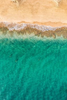 Beach with turquoise water on Fuerteventura island, Spain, Canary islands. Aerial view of sand beach, ocean texture background, top down view of beach by drone. Fuerteventura, Spain, Canary islands.