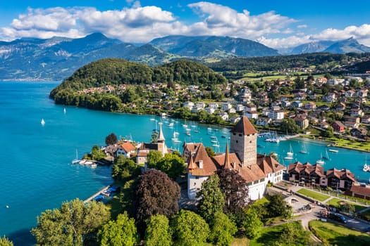 Aerial panoramic view of Spiez Church and Castle on the shore of Lake Thun in the Swiss canton of Bern at sunset, Spiez, Switzerland. Spiez Castle on lake Thun in the canton of Bern, Switzerland.