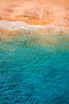 Beach with turquoise water on Fuerteventura island, Spain, Canary islands. Aerial view of sand beach, ocean texture background, top down view of sea waves by drone. Fuerteventura, Spain.