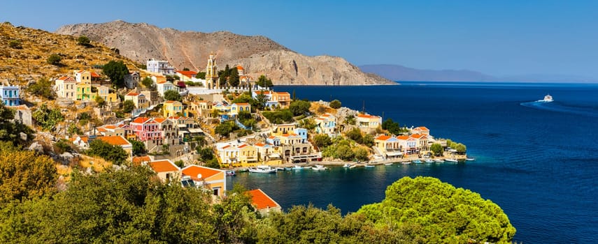 View of the beautiful greek island of Symi (Simi) with colourful houses and small boats. Greece, Symi island, view of the town of Symi (near Rhodes), Dodecanese.