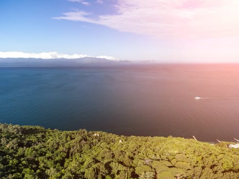 Sea landscape with rocky coastline on sunset time with cloudy sky. Yachts in the Sea on a background of rocky shores. The concept of perfect place for summer travel and rest.