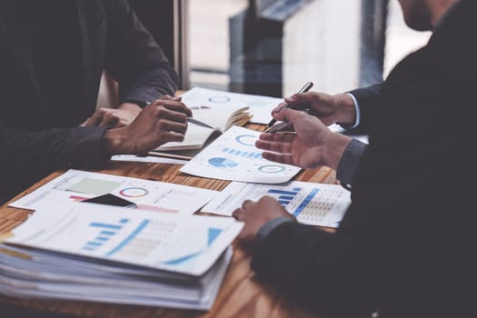 Close up of Diverse colleagues gather brainstorm discuss financial statistics at office meeting. finance, teamwork, Big data Graphs Charts concept.