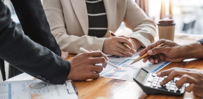 Business People Meeting using laptop computer,calculator,notebook,stock market chart paper for analysis Plans to improve quality next month. Conference Discussion Corporate Concept....