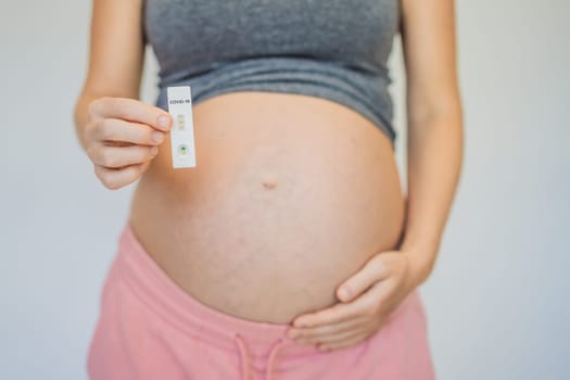 Pregnant woman making test. Close up of fingers holding express antigen covid corona test.