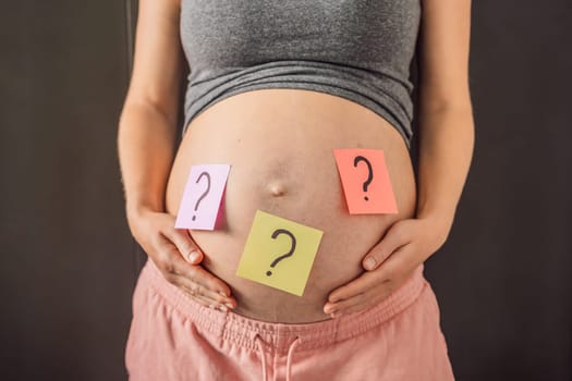 Choosing baby name. Confused pregnant woman with question marks on paper stickers on tummy.