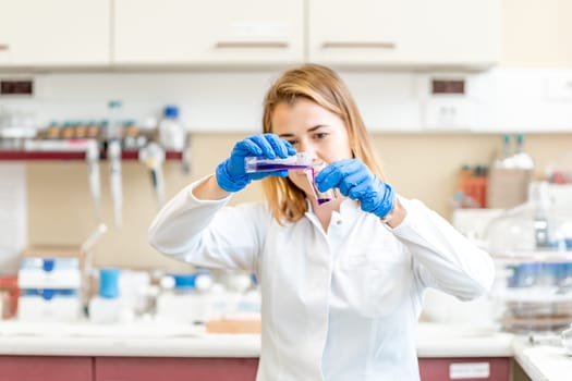 young female scientist conducts chemical experiments in a research laboratory.
