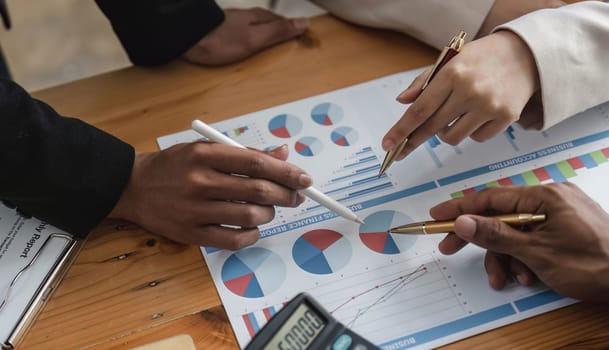 Business People Meeting using laptop computer,calculator,notebook,stock market chart paper for analysis Plans to improve quality next month. Conference Discussion Corporate Concept....