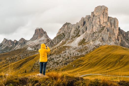 A tourist snaps photos of meadows nestled in the picturesque Alpine mountain range.